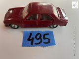 une petite voiture rouge sur laquelle est accrochée une étiquette de prix