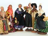 five figurines of women dressed in traditional clothing