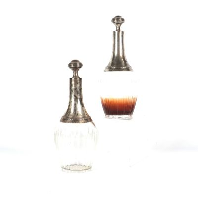 deux bouteilles d'alcool posées l'une à côté de l'autre sur une surface blanche