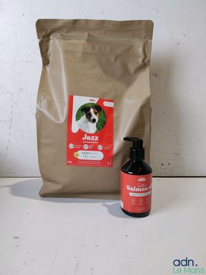 un sac de croquettes pour chien à côté d'une bouteille de liquide