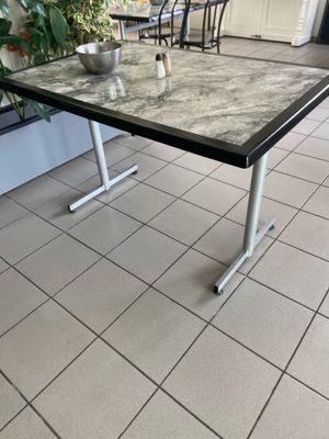 une table sur laquelle est posé un bol, posée sur un sol carrelé