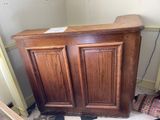 a wooden cabinet that is in the corner of a room