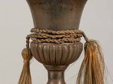 un vase en argent surmonté d'un pompon