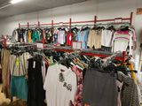 de nombreuses chemises suspendues à un portant dans un magasin