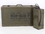 an old green suitcase sitting next to a small metal box