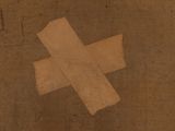 a piece of paper taped to the ground with a cross on it
