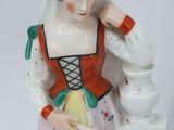 a figurine of a woman in a red and yellow dress