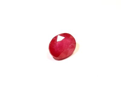 gros plan d'une pierre de rubis rouge sur une surface blanche