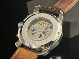 a close up of a watch with a brown leather strap
