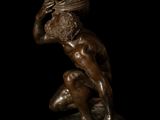 bronze statue of a kneeling man with a helmet on his head