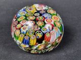 a picture of a multicolored paperweight on a black surface
