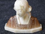 a small statue of a woman sitting on top of a table