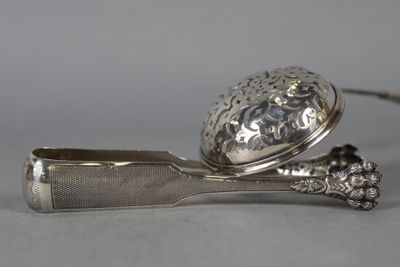 une cuillère en argent sur laquelle repose une cuillère