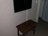 une petite table sur laquelle est posée une télévision, dans un coin de la pièce