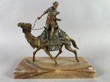 statue d'un homme à dos de chameau, posée sur un socle en marbre