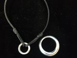un gros plan d'un collier et d'une bague posés sur une surface noire