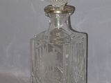 une bouteille en verre transparent munie d'un bouchon argenté