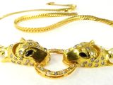 an image of a gold necklace with two cats on it