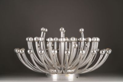 a silver vase with many balls in it on a table