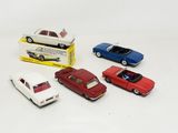 several toy cars are lined up in a row in front of a box