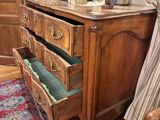 a wooden dresser with drawers and a lamp on top of it