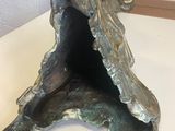 a metal sculpture of a shell on a white table