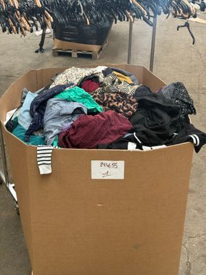 un carton rempli de vêtements posé sur le trottoir