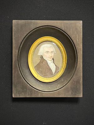 une vieille photo d'un homme vêtu d'un manteau marron bordé de jaune