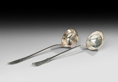 une paire de cuillères et une fourchette en argent posées sur un plateau blanc