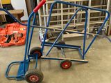 un diable bleu avec une poignée rouge dans un garage