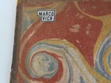 an old book with a picture of a swirly design on it