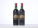 two bottles of red wine sitting on top of a table