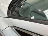 a white car with a black stripe parked in a parking lot