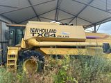 un tracteur qui est garé dans l'herbe près d'un bâtiment