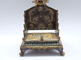 une petite chaise surmontée d'une tête de dragon