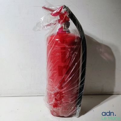 un extincteur rouge emballé dans du plastique