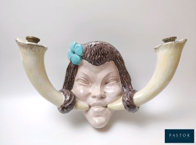 une figurine représentant une femme avec des cornes et un nœud sur la tête