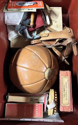 a brown leather box filled with books and a leather ball