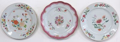 three plates with floral designs are lined up on a white surface