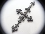 a cross made out of metal on a white surface