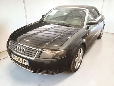 une voiture noire garée dans un garage au sol blanc
