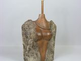 sculpture représentant un torse féminin posé sur un rocher, surmonté d'une lampe