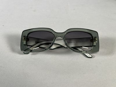 sunglasses on a table with a white table cloth and a white background