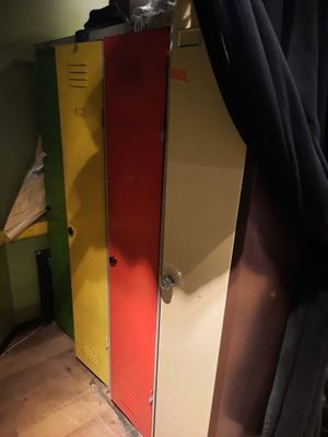 des casiers aux couleurs vives dans un coin d’une pièce séparée par un rideau noir