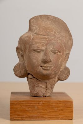 statue of a woman ' s head on a wooden base