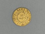a close up of a gold coin on a gray surface