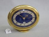 une horloge dorée au cadran bleu posée sur une table