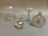 three glass vases and a small bottle on a table