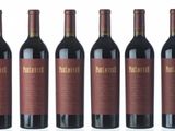 six bottles of red wine are lined up on a white surface