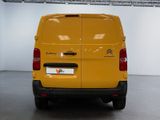 the back of a yellow van parked inside of a building